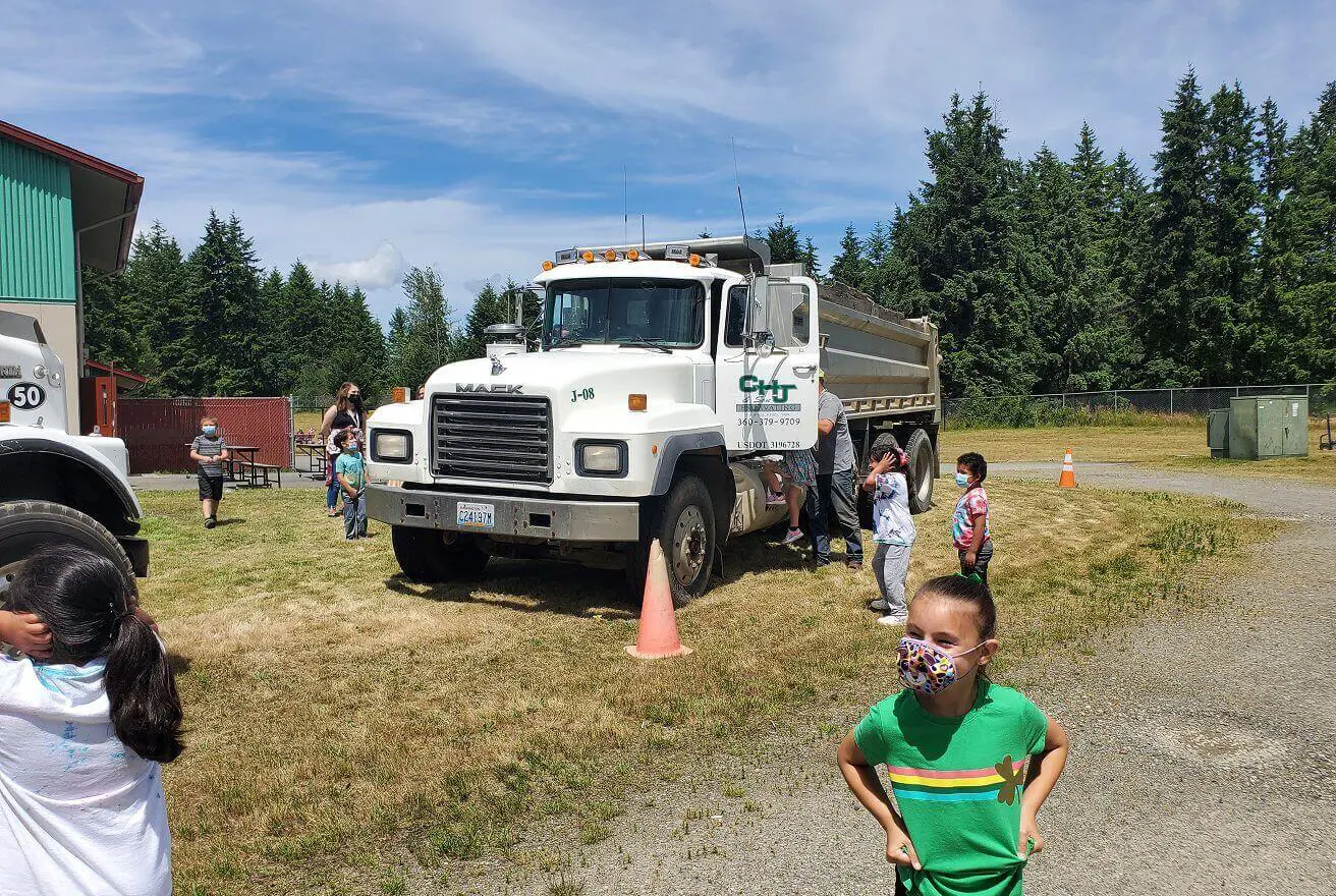 Children playing near a large white truck.