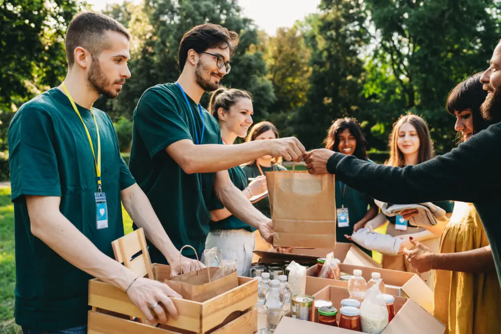 Volunteers packing food and supplies at an outdoor charity event.