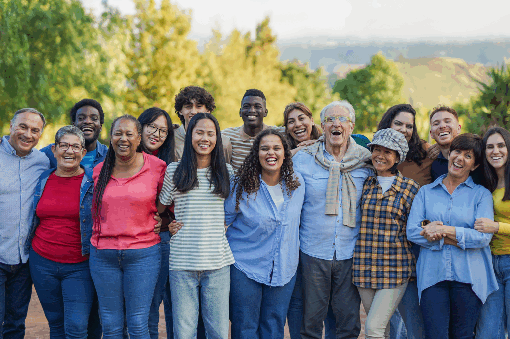 A diverse group of people smiling outdoors in a friendly setting.
